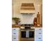 Close-up of stainless steel stove with wood countertops and accents, and subway tile backsplash at 8503 E Jamison Ave, Centennial, CO 80112