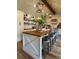 Spacious kitchen island with wood countertop and seating for five, with white cabinets and storage at 8503 E Jamison Ave, Centennial, CO 80112
