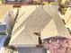 Aerial roof view of a home with gray shingles, red brick trim, driveway, and a landscaped yard at 12948 E 106Th Way, Commerce City, CO 80022