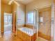 Bathroom with bathtub, tiled shower, and window for natural light at 12948 E 106Th Way, Commerce City, CO 80022