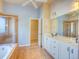 Bathroom with glass-enclosed shower, soaking tub, and double sink vanity at 12948 E 106Th Way, Commerce City, CO 80022