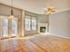 Spacious living room with a cozy fireplace and French doors leading to the outdoor area at 12948 E 106Th Way, Commerce City, CO 80022
