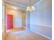 Open living room with neutral carpet, red front door, and ample natural light at 12948 E 106Th Way, Commerce City, CO 80022
