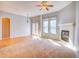 Light-filled living area with a fireplace, neutral-toned walls, and a ceiling fan at 12948 E 106Th Way, Commerce City, CO 80022