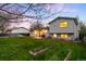 Spacious backyard with green lawn and the home's exterior at sunset at 8512 W Star Cir, Littleton, CO 80128