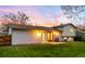 An inviting backyard with a well-maintained lawn and the home's exterior at sunset at 8512 W Star Cir, Littleton, CO 80128