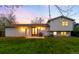 An inviting backyard with a well-maintained lawn and the home's exterior at sunset at 8512 W Star Cir, Littleton, CO 80128