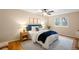 Bright bedroom featuring a ceiling fan, wood floors, an accent wall, and a cozy queen-size bed at 8512 W Star Cir, Littleton, CO 80128