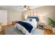 Comfortable bedroom featuring a ceiling fan, wood floors, an accent wall, and a cozy queen-size bed at 8512 W Star Cir, Littleton, CO 80128