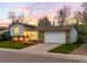 Well-maintained home with a two-car garage and neat front lawn at sunset at 8512 W Star Cir, Littleton, CO 80128