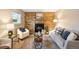 Inviting living room featuring a charming brick fireplace and cozy, neutral decor with soft, natural light at 8512 W Star Cir, Littleton, CO 80128