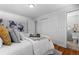 Bright bedroom with warm wood floors, comfortable bed with stylish pillows, and ample closet space at 2637 S Tennyson Way, Denver, CO 80219