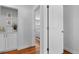 Hallway view with wood floors, fresh paint, and an open doorway to the bedroom and the rest of the home at 2637 S Tennyson Way, Denver, CO 80219