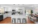 Open concept kitchen and dining area featuring white cabinets, stainless steel appliances, and island seating at 2637 S Tennyson Way, Denver, CO 80219