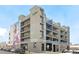 Modern apartment building featuring colorful murals, multiple balconies, and street parking at 3198 Blake St # 502, Denver, CO 80205