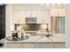Bright kitchen island with a sink, countertops, and ample storage with stainless steel appliances at 3198 Blake St # 502, Denver, CO 80205