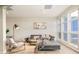 Cozy living room with large windows, a stylish sofa, decor, and a floor lamp at 3198 Blake St # 502, Denver, CO 80205