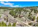 Scenic aerial view of a secluded red home with outbuilding surrounded by trees and natural beauty at 548 Coughlin Meadows Rd, Boulder, CO 80302