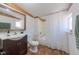 Bright bathroom with a vanity, toilet, and shower featuring a white shower curtain and a framed mirror at 548 Coughlin Meadows Rd, Boulder, CO 80302