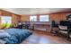 Spacious bedroom with wood paneling on the walls, two windows, and a full-sized bed with blue linens at 548 Coughlin Meadows Rd, Boulder, CO 80302