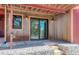 Covered patio featuring stone steps, gabion walls, corrugated metal siding, and a sliding glass door at 548 Coughlin Meadows Rd, Boulder, CO 80302