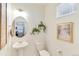Stylish powder room featuring a pedestal sink, framed print, and wall-mounted leafy decor at 22315 E 6Th Ave, Aurora, CO 80018
