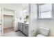 Bright bathroom featuring a double vanity, modern fixtures, and an open walk-in closet for convenient storage at 22315 E 6Th Ave, Aurora, CO 80018