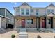 Charming townhouse with stone accents, a covered porch, and a striking red front door at 22315 E 6Th Ave, Aurora, CO 80018
