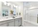 Clean, bright bathroom with double sinks, vanity with cabinets, and glass-enclosed shower at 22315 E 6Th Ave, Aurora, CO 80018