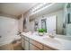 Bright bathroom with a double sink vanity, large mirror, and tub with white tile surround at 9911 E Idaho Cir # 202, Denver, CO 80247