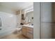 Well-lit bathroom with tiled shower, tub, vanity, and storage cabinet at 9911 E Idaho Cir # 202, Denver, CO 80247