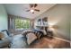 Inviting bedroom featuring a large window, ceiling fan, and warm accents at 9911 E Idaho Cir # 202, Denver, CO 80247