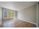 Bright, empty bedroom with hardwood floors, neutral walls, and a large window at 9911 E Idaho Cir # 202, Denver, CO 80247