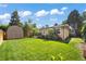 Large backyard featuring a lush lawn, storage shed, and mature trees for privacy at 1380 Magnolia St, Denver, CO 80220