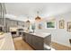 Bright kitchen featuring a large island, pendant lights, ample cabinet space, and stainless steel appliances at 1380 Magnolia St, Denver, CO 80220