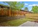 Landscaped backyard featuring grass, wooden fence, concrete patio, and a retaining wall at 15323 E Louisiana Ave, Aurora, CO 80017