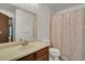 Bathroom with vanity, toilet, and shower with patterned shower curtain at 15323 E Louisiana Ave, Aurora, CO 80017