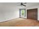 Bright bedroom with carpet flooring, ceiling fan, and window overlooking outdoor greenery at 15323 E Louisiana Ave, Aurora, CO 80017