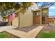 Charming townhome features a brick facade, attached garage, sidewalk, and American flag at 15323 E Louisiana Ave, Aurora, CO 80017