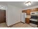 Traditional kitchen with wood cabinets, white appliances, and light countertops at 15323 E Louisiana Ave, Aurora, CO 80017