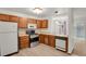 Bright eat-in kitchen featuring wood cabinets, updated appliances, and laminate flooring at 15323 E Louisiana Ave, Aurora, CO 80017