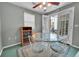 Inviting dining area featuring a glass table, white chairs and a ceiling fan with natural light streaming in from the patio at 8300 Fairmount Dr # Ff104, Denver, CO 80247