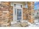 Charming front entrance with a white door with a window and stone pillars on either side at 8300 Fairmount Dr # Ff104, Denver, CO 80247