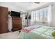 Comfortable bedroom featuring ceiling fan, shutters, and large dresser with TV at 4620 Blackhawk Way, Denver, CO 80239