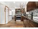 Well-lit kitchen with stainless steel appliances, dark cabinets, and hardwood floors at 4620 Blackhawk Way, Denver, CO 80239