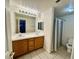 Bathroom features a double sink vanity and shower with patterned curtain at 7440 S Blackhawk St # 208, Englewood, CO 80112