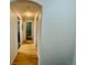A view down a hallway with hardwood floors, featuring neutral wall colors and archway at 7440 S Blackhawk St # 208, Englewood, CO 80112