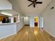 Open living area with hardwood floors, bright lighting, and entry to hall and bathroom at 7440 S Blackhawk St # 208, Englewood, CO 80112