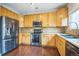 Well-lit kitchen features stainless steel appliances and ample counter space with wood cabinets at 2446 S Gibralter Way, Aurora, CO 80013