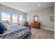 Bright bedroom featuring large windows, wood floors, and charming dresser with ornate mirror at 11136 Sweet Cicely Dr, Parker, CO 80134